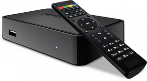 Black media streaming device with a remote control on top, featuring colorful buttons and a sleek design